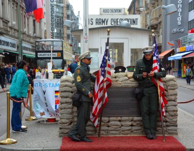 BERLİN, GERMANY - 08 23 17: Amerikan askeri gibi giyinmiş kimliği belirsiz genç adamlar Charlie 'nin soğuk savaşı hatırladığı kontrol noktasının önünde duruyorlar