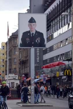 BERLİN, ALMANY - 08 23 17: ABD askerinin eski Doğu-Batı Berlin sınırındaki fotoğrafı, Charlie 'nin soğuk savaşı hatırladığı kontrol noktası