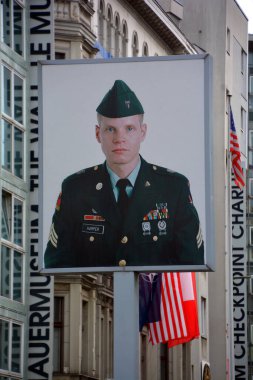 BERLİN, ALMANY - 08 23 17: ABD askerinin eski Doğu-Batı Berlin sınırındaki fotoğrafı, Charlie 'nin soğuk savaşı hatırladığı kontrol noktası
