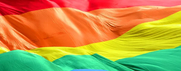 Textile rainbow flag with waves, symbol of freedom of choice of lesbians, gays, bisexuals and transgender people, LGBT culture, close up