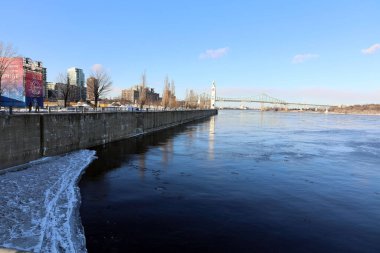 view of the river and the bridge in the city at winter