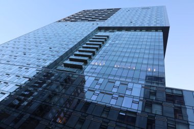 modern glass building with blue sky and white clouds