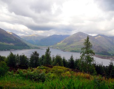 Göl ve dağlarla dolu güzel bir manzara.