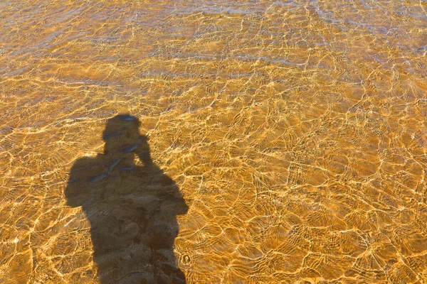 Man shadow, sea Water and Sand Structure Golden fine sand on the shoreline, creating abstract pattern during the tide