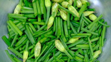 Çelik bir kasede kesilmiş sarımsak soğanları..