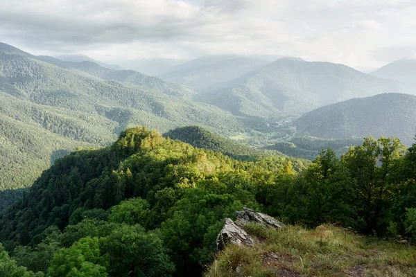 Mountains with a forest in the Caucasus mountains, a view from the topto a mountain village in the valley — Stock fotografie