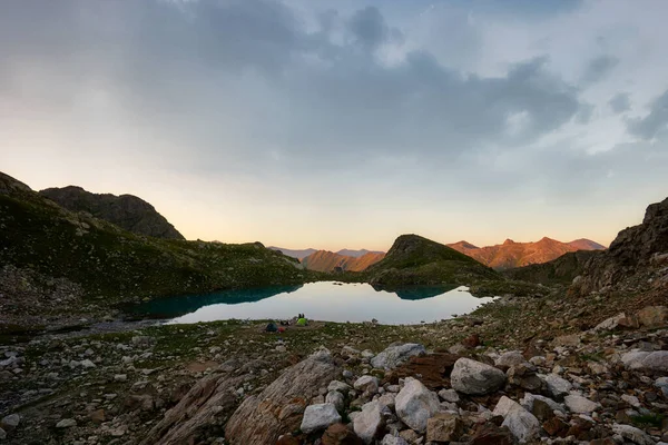 Panorámás kilátás türkiz tó környező éles csúcsok hegyek a völgyben a napsütéses nyári napon — Stock Fotó