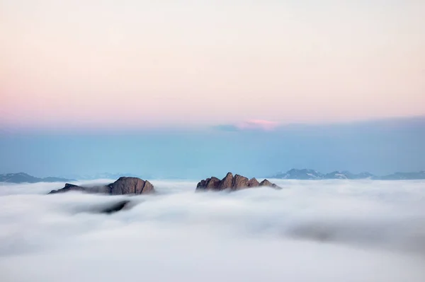 Atemberaubender Sonnenaufgang und Nebel über den Bergen. Nebliger Morgenhimmel mit aufgehender Sonne über dem nebligen Naturpark Großthach Stockbild