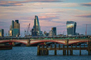 Ofis binaları, gökdelenler, mavi gökyüzü ve bulutların arka planına, Thames nehrine, köprüye, İngiltere 'nin Londra ilçesine karşı iş yapan kiliseler var. Web siteleri, broşürler, posterler, baskı ve tasarım için kullanılabilir.