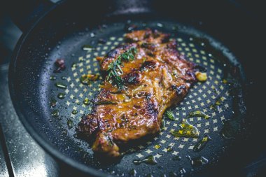 Biberiyeli biftek, sarımsak, tuz ve biber demir tavada.
