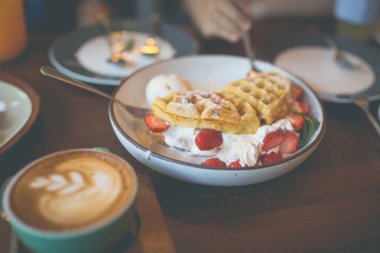 Bir sürü waffle ve kekle sütlü kahve.