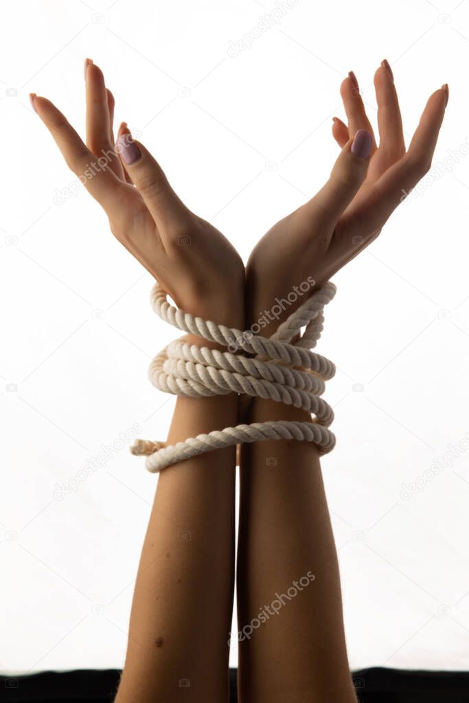 Tied female hands isolated on white background.