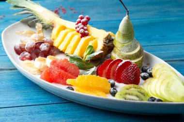 Meyve tabağı. Mavi, ahşap bir arka planda. Seçici odak