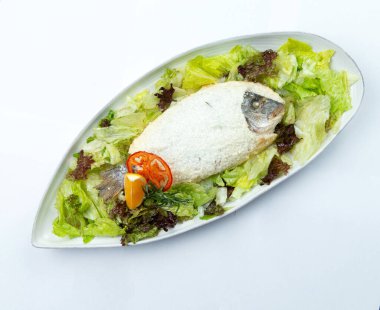 Dorado bir tabakta tuzla pişirildi. Beyaz arka planda izole edilmiş. Seçici odak.