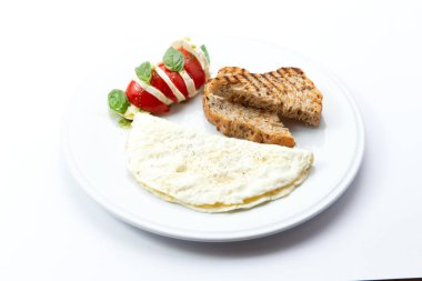 Omlet ve tost tabakta. Beyazda izole edilmiş. Seçici odak.