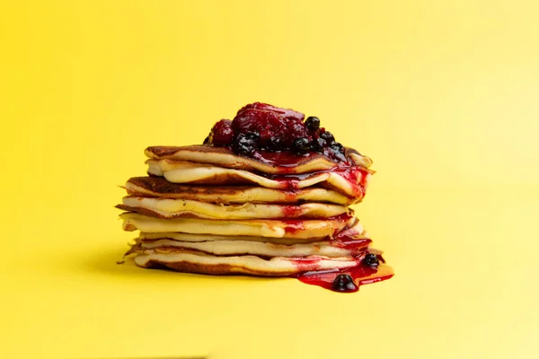 Stapel Von Pfannkuchen Mit Beerenmarmelade Auf Gelbem Hintergrund — Stockfoto