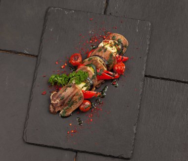 Kızarmış dil ve sebze. Yukarıdan bak. Taş bir arka planda.