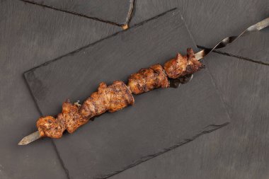 Şişte kızarmış domuz şişi. Yukarıdan bak. Taş bir arka planda.