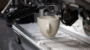 Close-up of a coffee machine makes coffee. Pours espresso into a cup. Selective focus.