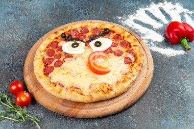 Homemade pizza in the form of an angry bird. Selective focus.