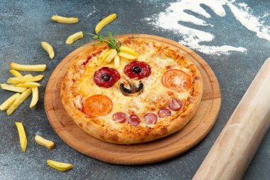 Homemade pizza in the form of a smiley On a gray background. Selective focus.
