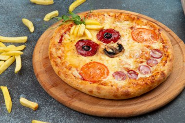 Homemade pizza in the form of a smiley On a gray background. Selective focus.