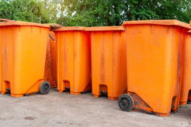  Halka açık bir yerde turuncu çöp kutusu. Çevreyi temiz ve rahat tutmak için gerekli malzemeler, Turuncu Plastik Atık Konteynırı veya Wheelie Bin.