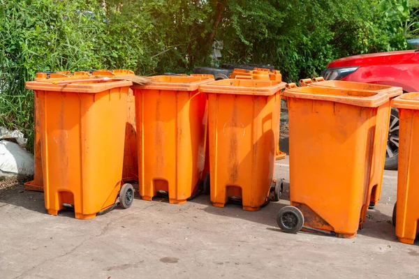  Halka açık bir yerde turuncu çöp kutusu. Çevreyi temiz ve rahat tutmak için gerekli malzemeler, Turuncu Plastik Atık Konteynırı veya Wheelie Bin.