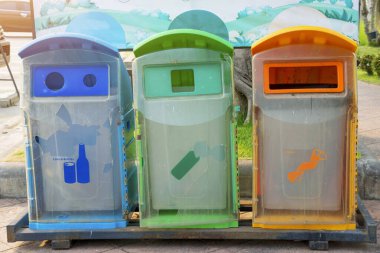 Blue, green, yellow, bin in the parking car.