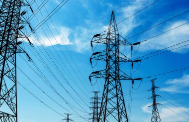 Mavi bulutlu gökyüzüne karşı elektrik direği, yüksek voltaj kulesi veya elektrik iletim hattı.
