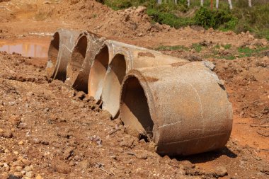 Çimenlerdeki eski beton borular çatlamış ve çürümüş kanalizasyon boruları bırakılır ya da yere yerleştirilir..
