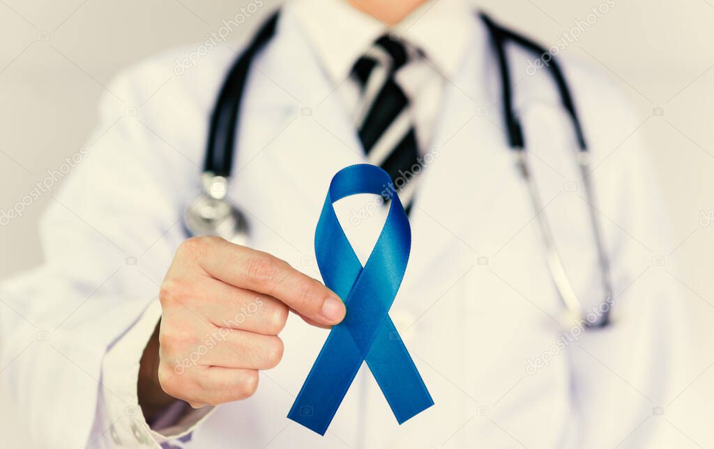 Doctor Holds Blue Ribbon,  Colon cencer Awareness. Symbolic concept raising awareness concerns help campaign on people living Colorectal cancer illness.