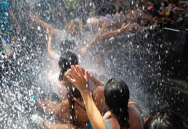 Мальчики и девочки участвуют в вечеринке с водой на улицах. Водная вечеринка.