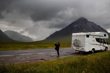 Karavanda yaşayan bir turist, Glen Etive 'in cep telefonuyla İskoçya' daki Glen Coe 'da fotoğraf çekiyor.