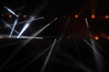 Sahne ışıklandırması. Sahnede renkli ışıkları olan spot ışıkları. Yapay ışıklandırma. Siyah arkaplan ve bulanık.