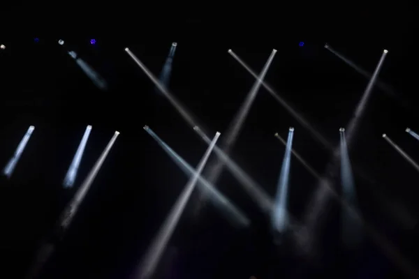 Stage lighting. Spotlights with colored lights on a stage. Artificial lighting. Black background and blur.