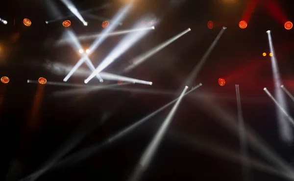 Stage lighting. Spotlights with colored lights on a stage. Artificial lighting. Black background and blur.