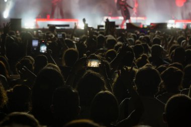 Konserde cep telefonu olan insanlar. Cep telefonlu eller. Bir konserde halk cep telefonuyla fotoğraf çekiyor..