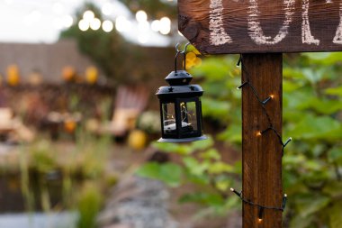 Küçük siyah bir fener panayırdaki ahşap bir tezgaha asılmış.