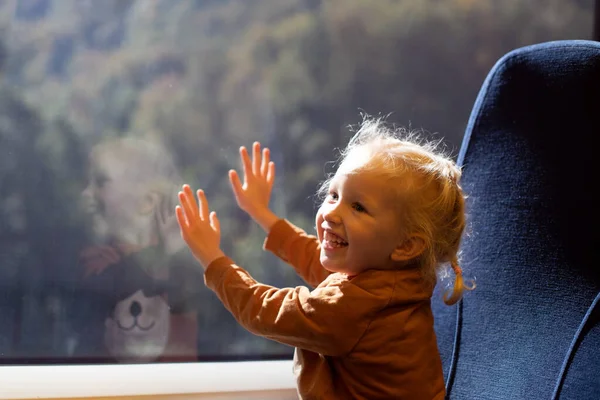 小女孩坐火车时看着窗户。公共交通 — 图库照片