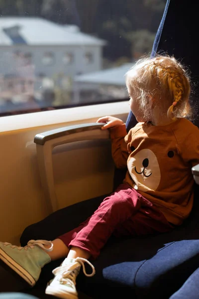 Niña mirando la ventana mientras viaja en tren. Transporte público — Foto de Stock