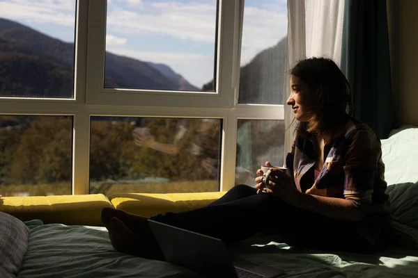 Werken vanuit huis. Vrouw zittend bed panoramisch uitzicht op de bergen werken — Stockfoto