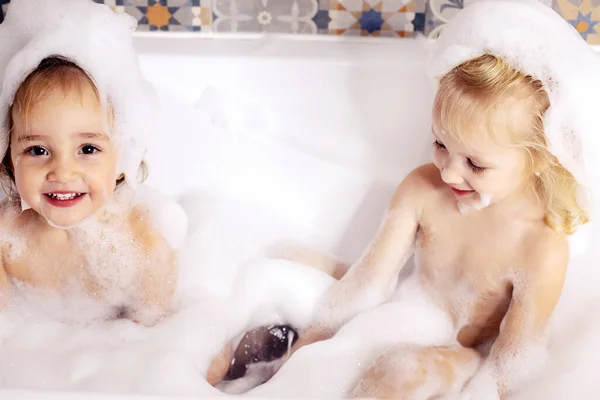 어린 여자 애 둘 이 욕실에서 목욕 거품 놀이를 즐기고 있어요. 자녀들의 개인적 돌봄 — 스톡 사진