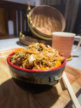 Bir kase baharatlı pilav, sebzeli, sahanda yumurta, erişte. Huysuz bir şekilde servis edilmiş. Seçici odak