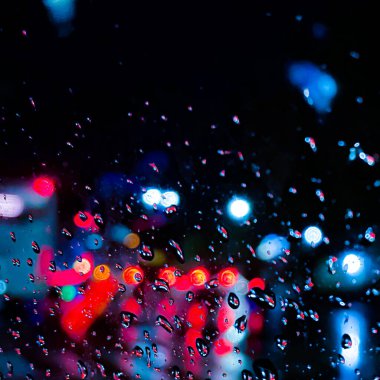 Cama bir damla su damlatıyor, nemli ve yağmurlu arkaplan soyut bir zemin ile renksiz ışıklarla kaplı.