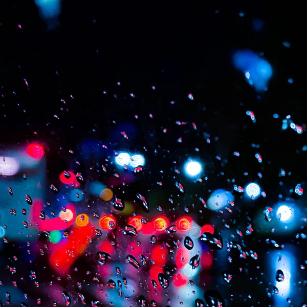 Cama bir damla su damlatıyor, nemli ve yağmurlu arkaplan soyut bir zemin ile renksiz ışıklarla kaplı.