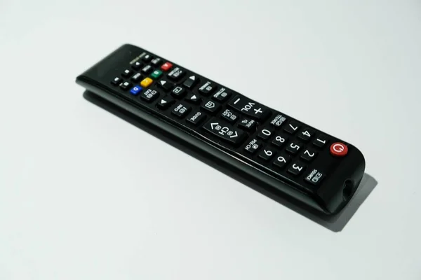 Beyaz arkaplanda izole edilmiş siyah bir TV uzaktan kumandasının üst açı görünümü