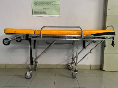 Hastane koridorunda sarı bir sedye.