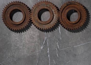 Gri arka planda paslı metal dişliler