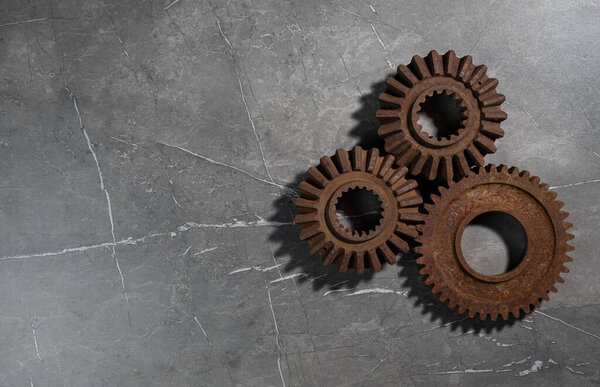 Old rusty metal gears on a gray background
